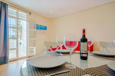 a table with a bottle of wine and two glasses at Apartamentos Ribera del Puerto in El Puerto de Santa María