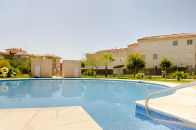 a large swimming pool with buildings in the background at Apartamentos Sanlúcar & Doñana in Sanlúcar de Barrameda