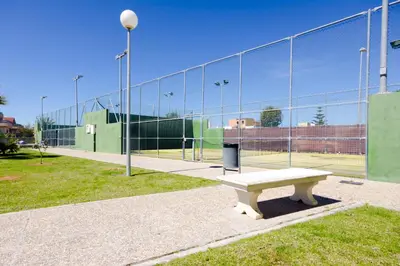 a park with a bench in front of a fence at Apartamentos Sanlúcar & Doñana in Sanlúcar de Barrameda