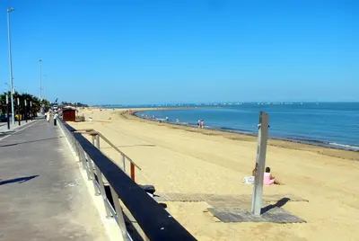 a child laying on the beach next to the ocean at Apartamentos Sanlúcar & Doñana in Sanlúcar de Barrameda