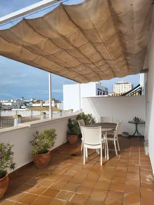 a patio with a table and chairs on a balcony at Apartamento en el centro con garaje, terraza, wifi, climatización y piscina in Sanlúcar de Barrameda