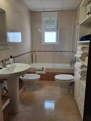 a bathroom with a sink and a toilet and a tub at Apartamento en el centro con garaje, terraza, wifi, climatización y piscina in Sanlúcar de Barrameda