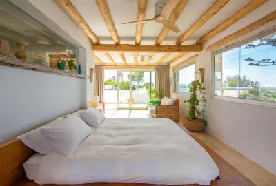 a bedroom with a large bed and a large window at Exotic Beachfront Retreat Handcrafted Bohemian Luxury in Cádiz
