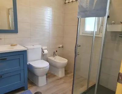 a bathroom with a toilet and a glass shower at La casa bianca in Novo Sancti Petri