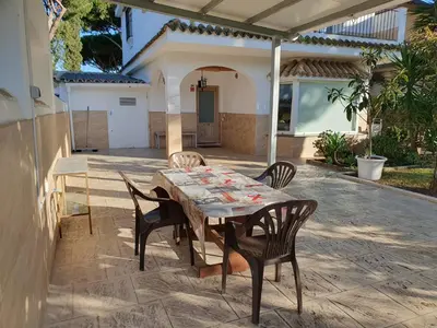 a wooden table and chairs on a patio at La casa bianca in Novo Sancti Petri