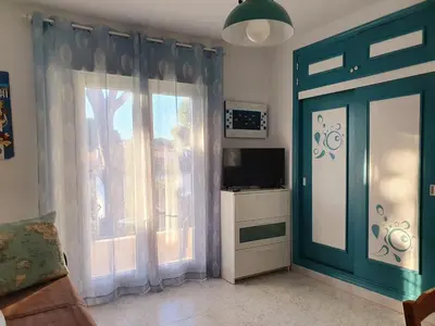a living room with a large window and a television at La casa bianca in Novo Sancti Petri