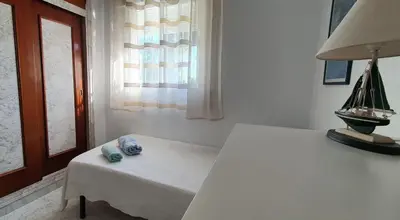 a room with a table and a lamp and a window at La casa bianca in Novo Sancti Petri