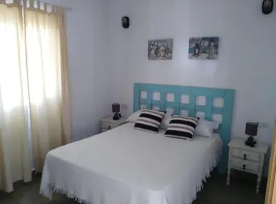 a bedroom with a blue bed with pillows on it at ALOJAMIENTo RURAL IZAN in Conil de la Frontera