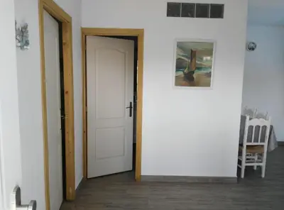 a hallway with a white door and a painting at ALOJAMIENTo RURAL IZAN in Conil de la Frontera