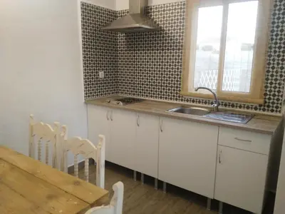 a kitchen with a sink and a table and a window at Casa MARINERA in Cádiz