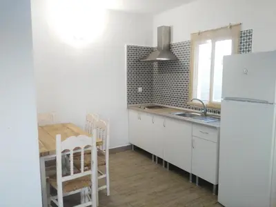 a kitchen with a white refrigerator and a table at Casa MARINERA in Cádiz