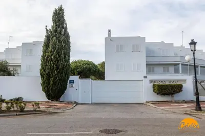 a white fence in front of a white building at Retama Golf by Cadiz Time in Novo Sancti Petri