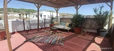 an outdoor patio with a couch and a rug at Oasis de Bornos Maison Entière in Bornos