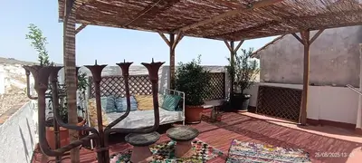 a patio with a bed on a deck at Oasis de Bornos Maison Entière in Bornos