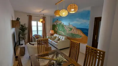 a living room with a couch and a painting on the wall at Atico Arcos Terraza Relax in Arcos de la Frontera