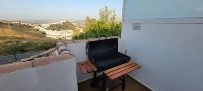 a balcony with a grill and a bench with a view at Atico Arcos Terraza Relax in Arcos de la Frontera