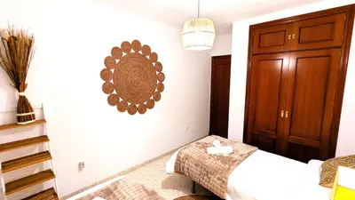 a bedroom with a bed and a mirror on the wall at Atico Arcos Terraza Relax in Arcos de la Frontera