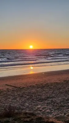 a sunset on a beach with the ocean at Librada de las olas in Cádiz