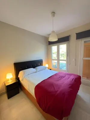 a bedroom with a large bed with a red blanket at apartamento rubí in El Puerto de Santa María