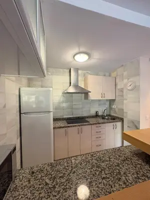 a kitchen with white cabinets and a white refrigerator at apartamento rubí in El Puerto de Santa María