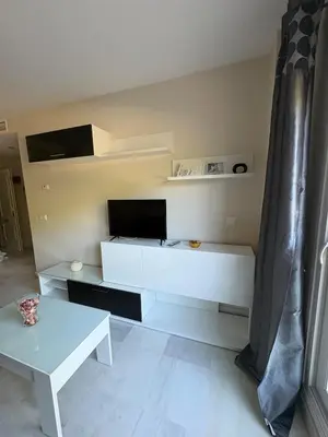 a white living room with a tv and a table at apartamento rubí in El Puerto de Santa María