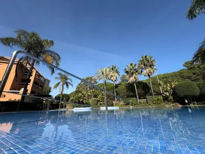 a swimming pool with water fountains in front of a building at apartamento rubí in El Puerto de Santa María