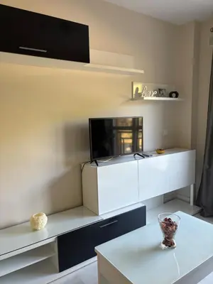 a living room with a tv and a white table at apartamento rubí in El Puerto de Santa María