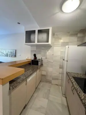 a kitchen with white cabinets and a refrigerator at apartamento rubí in El Puerto de Santa María