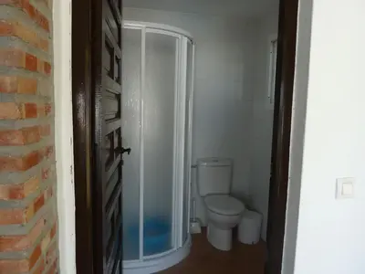 a bathroom with a toilet and a walk in shower at Chalet Rancapinos en Rocheviejo CONIL in Cádiz