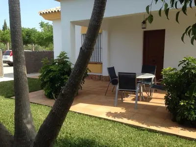 a patio with a table and chairs in a yard at Chalet Rancapinos en Rocheviejo CONIL in Cádiz