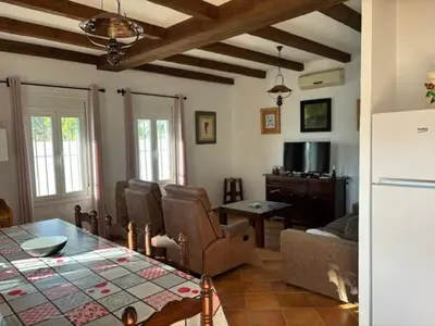 a kitchen and living room with a table and a couch at Chalet Rancapinos en Rocheviejo CONIL in Cádiz
