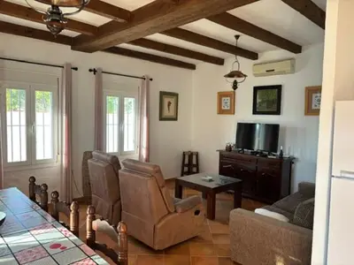 a living room with a couch and a tv at Chalet Rancapinos en Rocheviejo CONIL in Cádiz