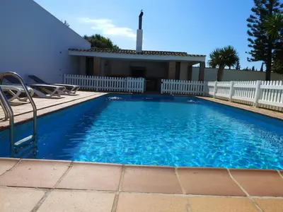 a swimming pool in a yard with a white fence at Chalet Rancapinos en Rocheviejo CONIL in Cádiz
