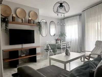a living room with a couch and a tv and a table at EXCLUSIVE APARTMENT 3 HAB Wifi in Rota