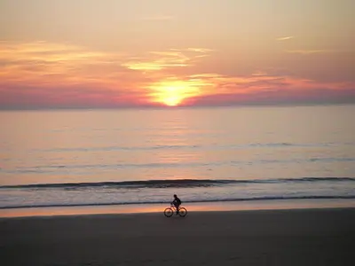 a person riding a bike on the beach at sunset at EXCLUSIVE APARTMENT 3 HAB Wifi in Rota