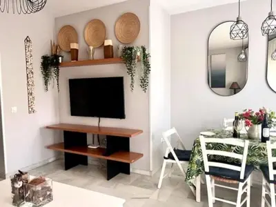 a living room with a television and a dining room at EXCLUSIVE APARTMENT 3 HAB Wifi in Rota