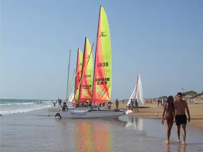 a group of sailboats on a beach with people on the beach at EXCLUSIVE APARTMENT 3 HAB Wifi in Rota