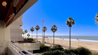 a view of a beach with palm trees and the ocean at Miramar Grupo AC Gestion in Cádiz