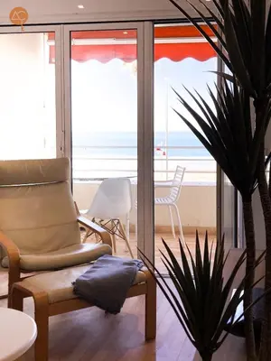 a chair and a plant in a room with a view of the ocean at Miramar Grupo AC Gestion in Cádiz