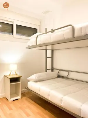 two bunk beds in a room with a lamp at Miramar Grupo AC Gestion in Cádiz