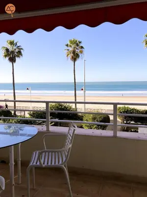 a patio with a table and chairs and a view of the beach at Miramar Grupo AC Gestion in Cádiz