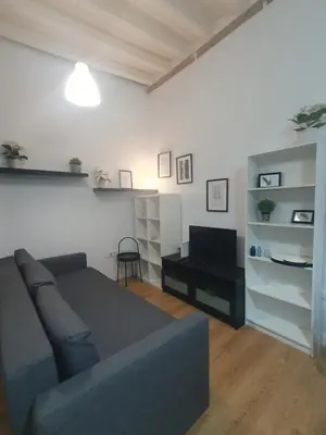 a living room with a couch and a desk at Casa Parque Genovés junto a la playa in Cádiz