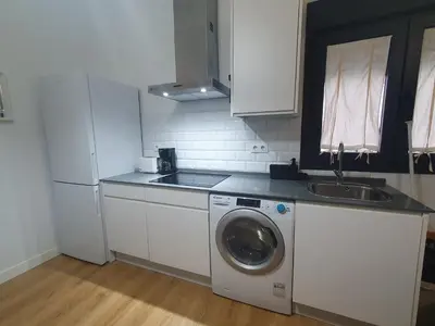 a kitchen with a washing machine and a sink at Casa Parque Genovés junto a la playa in Cádiz