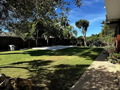 a yard with green grass and trees and a driveway at Casa singular completamente reformada in El Puerto de Santa María