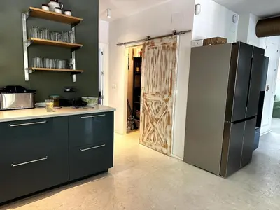 a kitchen with black cabinets and a wooden door at Casa singular completamente reformada in El Puerto de Santa María