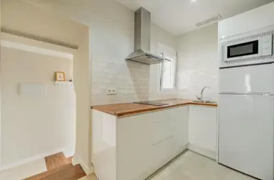 a white kitchen with white cabinets and a sink at Loft Casa del Duque in Arcos de la Frontera