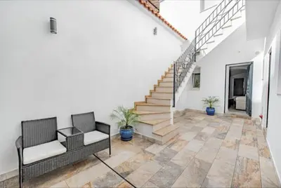 a living room with two chairs and stairs at Loft Casa del Duque in Arcos de la Frontera