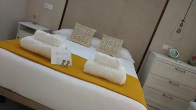 a bedroom with a bed with white sheets and pillows at Loft Casa del Duque in Arcos de la Frontera
