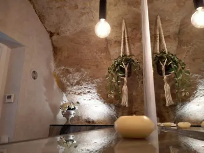 a room with potted plants hanging on a wall at La Cueva del Corregidor in Arcos de la Frontera