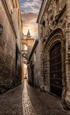 an alley with an archway in an old building at La Cueva del Corregidor in Arcos de la Frontera
